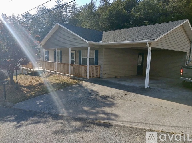 A house with a porch and a driveway in front.
