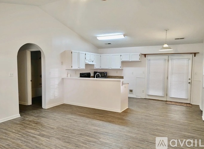 A spacious kitchen with white cabinets and a central island.