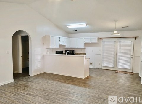 A spacious kitchen with white cabinets and a central island.