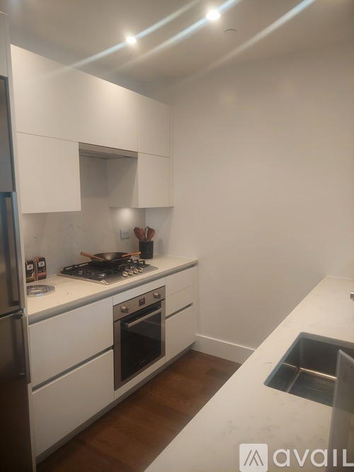 A kitchen with white cabinets and a stainless steel refrigerator.