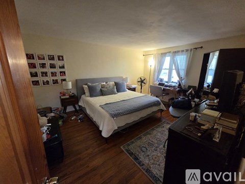 A bedroom with a bed, nightstand, and a fan.