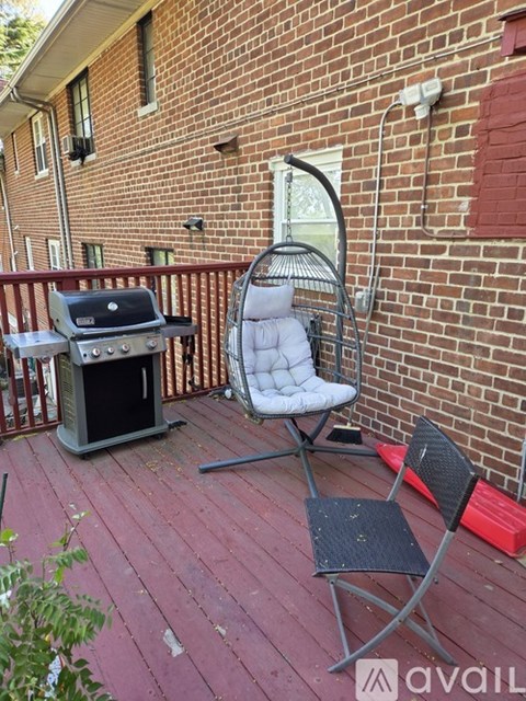 A patio with a BBQ grill and chairs.