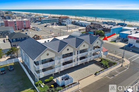 A beachfront apartment complex with a red arrow pointing to a specific unit.