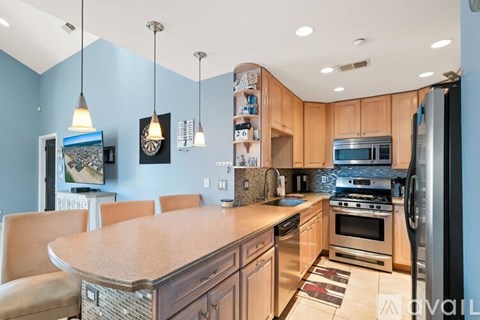 A kitchen with a blue wall and wooden cabinets.