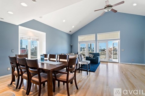 A dining room with a table and chairs and a ceiling fan.