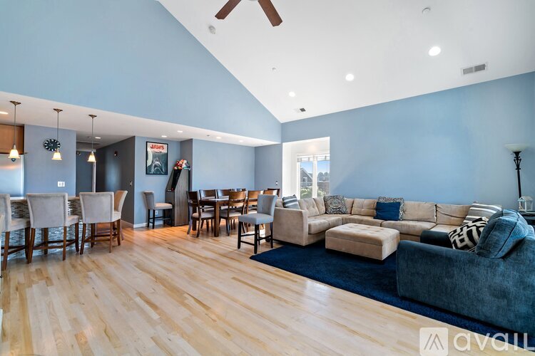A living room with a blue couch and a wooden floor.