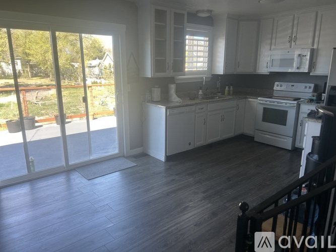 A kitchen with white appliances and cabinets is available for rent.