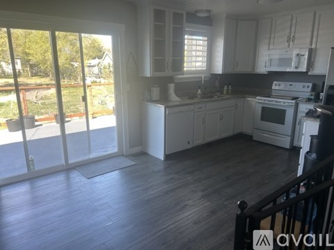 A kitchen with white appliances and cabinets is available for rent.