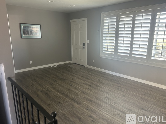 A room with wooden flooring and a white door.