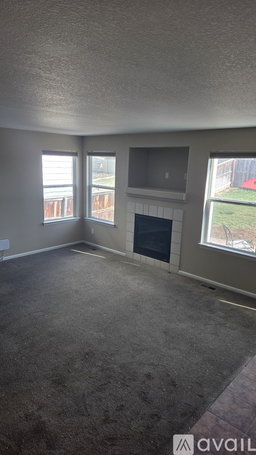 A room with a fireplace and a window.
