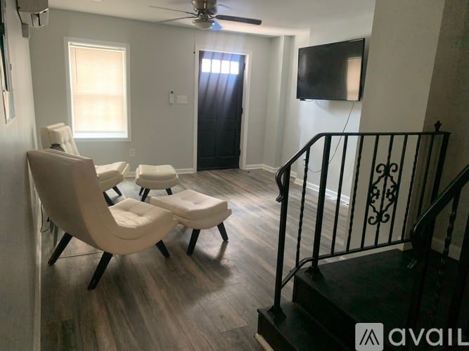 A living room with a staircase and a television.