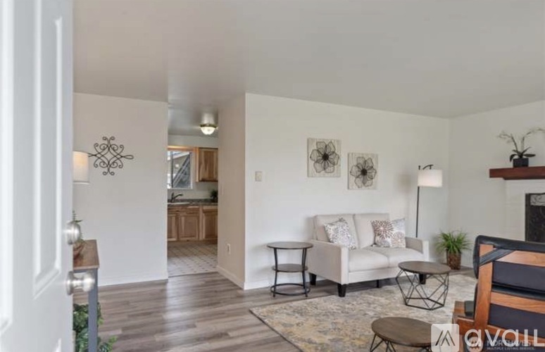 A living room with a white couch and a rug.