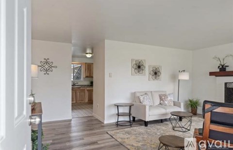 A living room with a white couch and a rug.