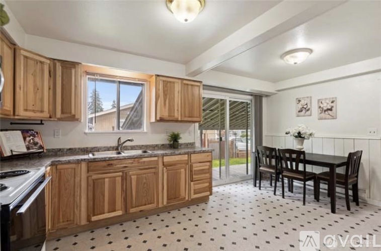 A kitchen with wooden cabinets and a black and white floor.