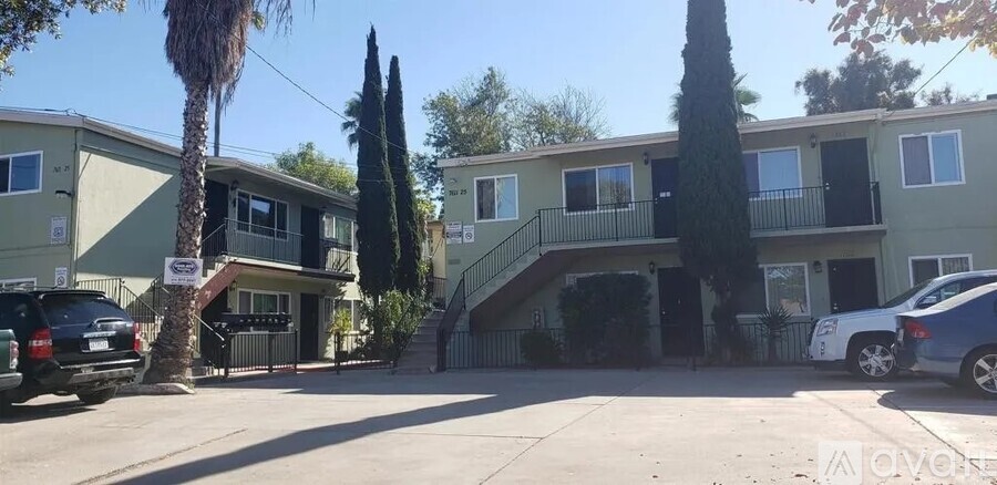 A sunny day in a quiet residential street with cars parked on the side.
