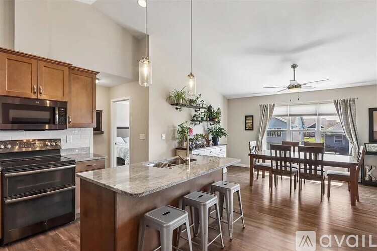 A modern kitchen with dark wood cabinets and a marble countertop.