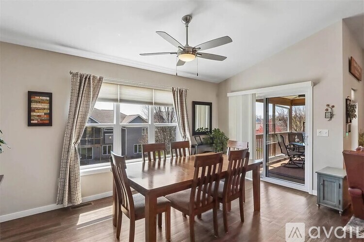 A dining room with a table set for six and a view of the backyard.