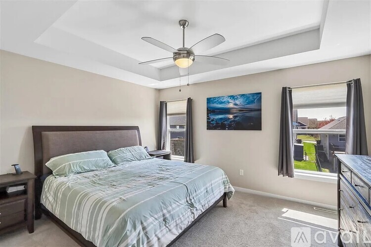 A bedroom with a large bed and a ceiling fan.