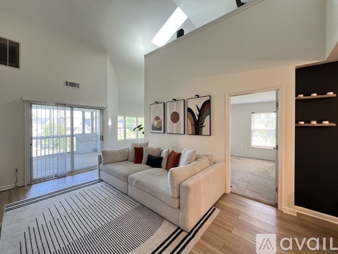 A living room with a white couch and a striped rug.