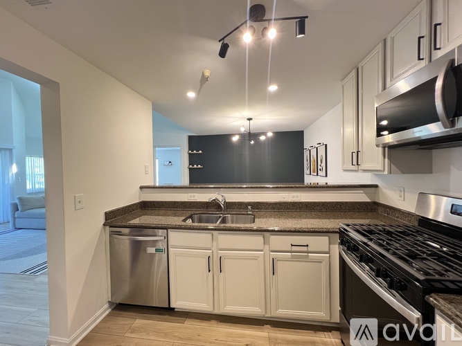 A kitchen with a stainless steel dishwasher and oven.