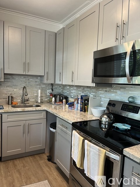 A kitchen with a black stove top oven and a black microwave above it.