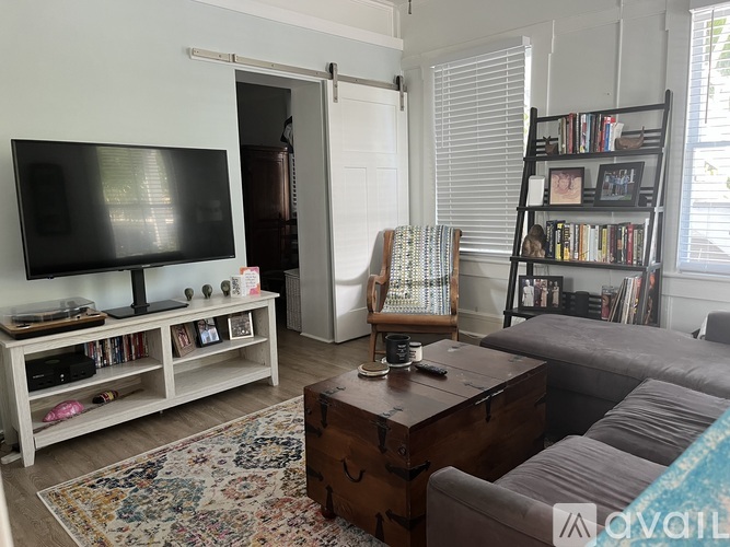 A living room with a television, a couch, and a bookshelf.