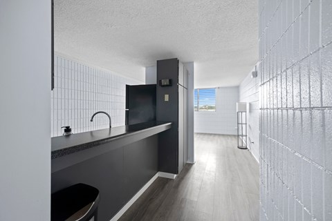 A modern kitchen with a black countertop and a sink.