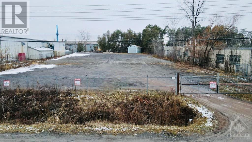 A realtor photo of a property with a fence and a sign that says "For Sale".