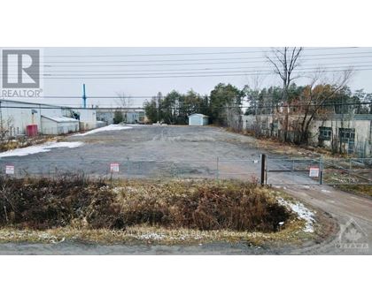 A realtor photo of a property with a fence and a sign that says "For Sale".