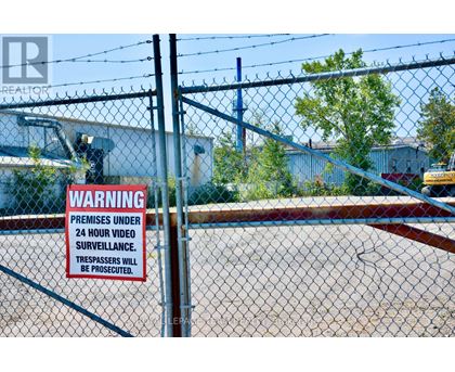 A sign on a fence warns that the premises are under 24 hour video surveillance and trespassers will be prosecuted.