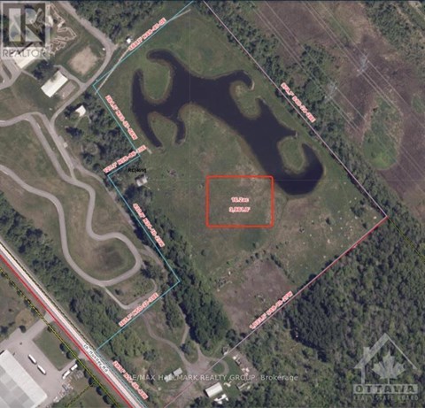 An aerial view of a property with a pond and a building.