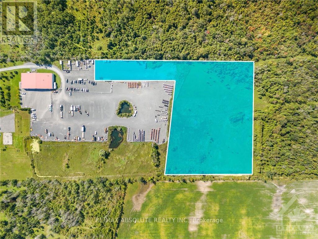An aerial view of a property with a large swimming pool and a parking lot.