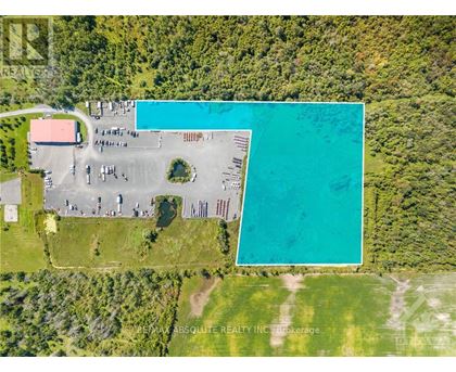 An aerial view of a property with a large swimming pool and a parking lot.
