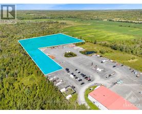A large swimming pool is surrounded by a parking lot and buildings.