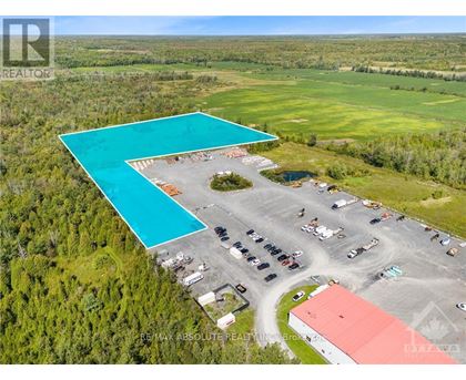 A large swimming pool is surrounded by a parking lot and buildings.