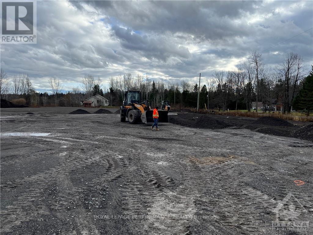 A construction site with a bulldozer and a person standing nearby.