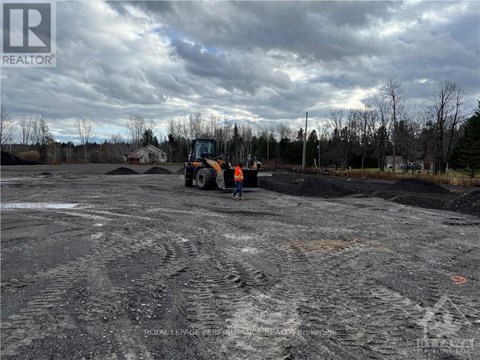 A construction site with a bulldozer and a person standing nearby.