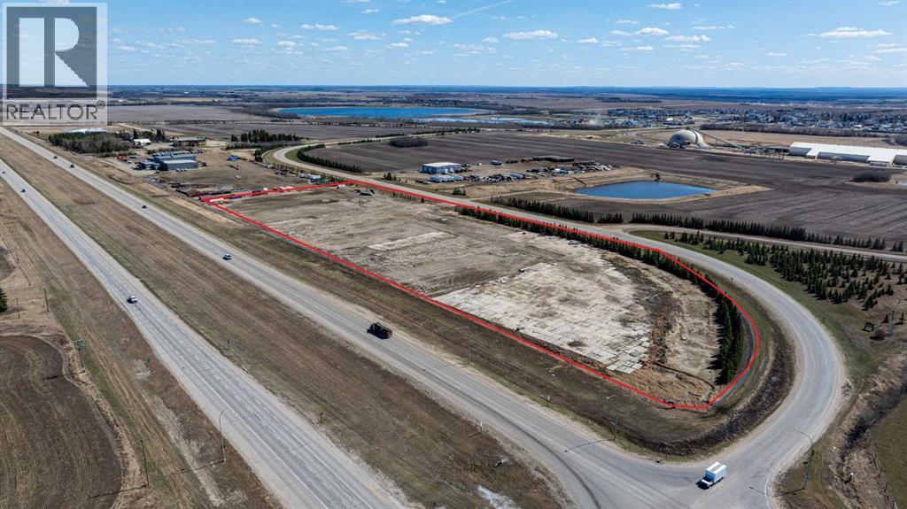 A realtor logo is visible on an aerial image of a road and surrounding land.