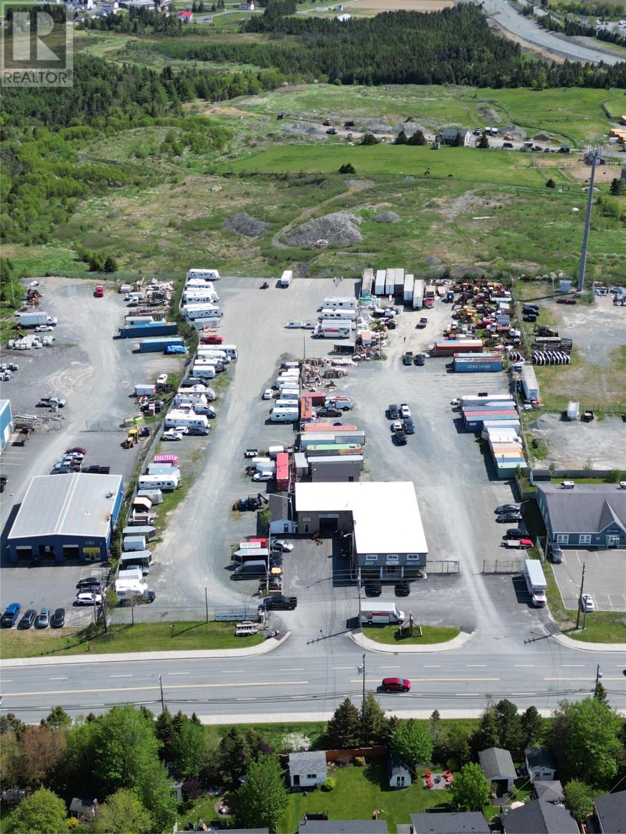 A parking lot with many cars and a few buildings.