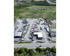 A parking lot with many cars and a few buildings.
