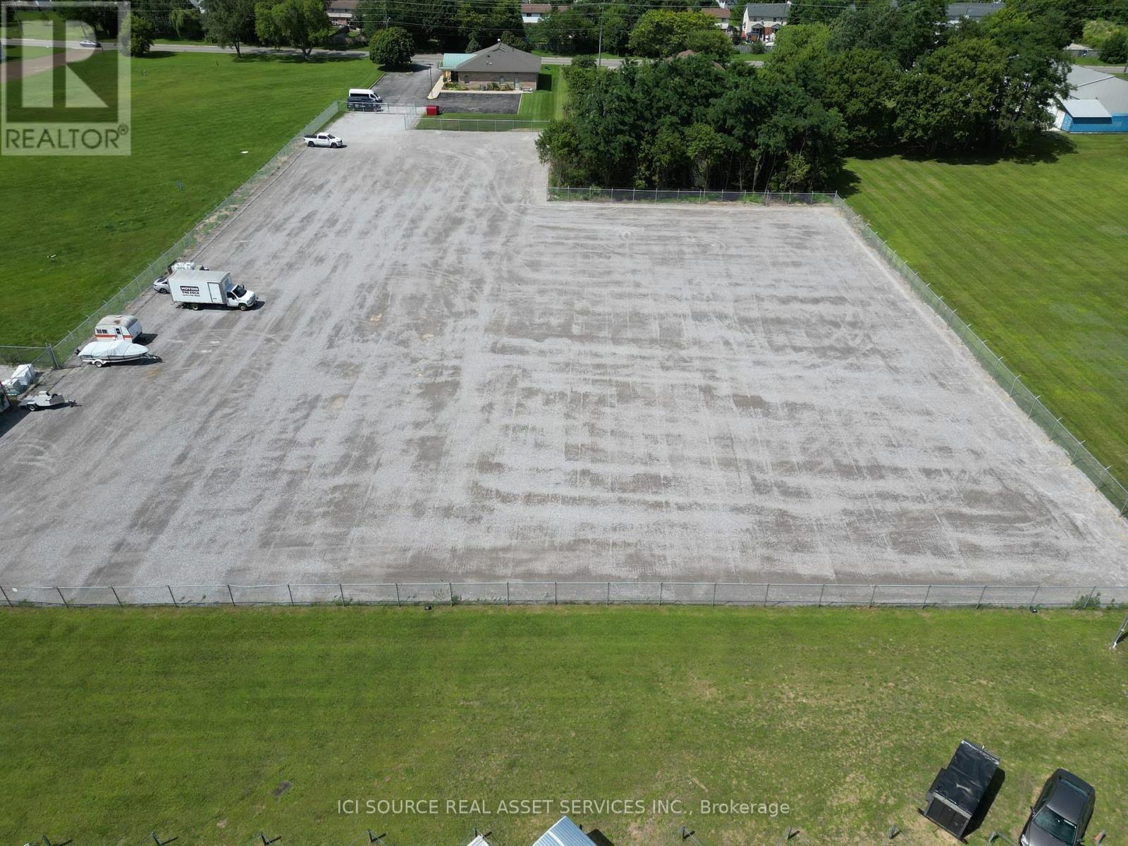 A large, empty parking lot with a few cars and a truck.