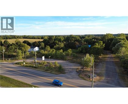A blue car is driving on a road with trees on the side.