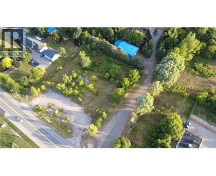 An aerial view of a green area with a blue building and a parking lot.