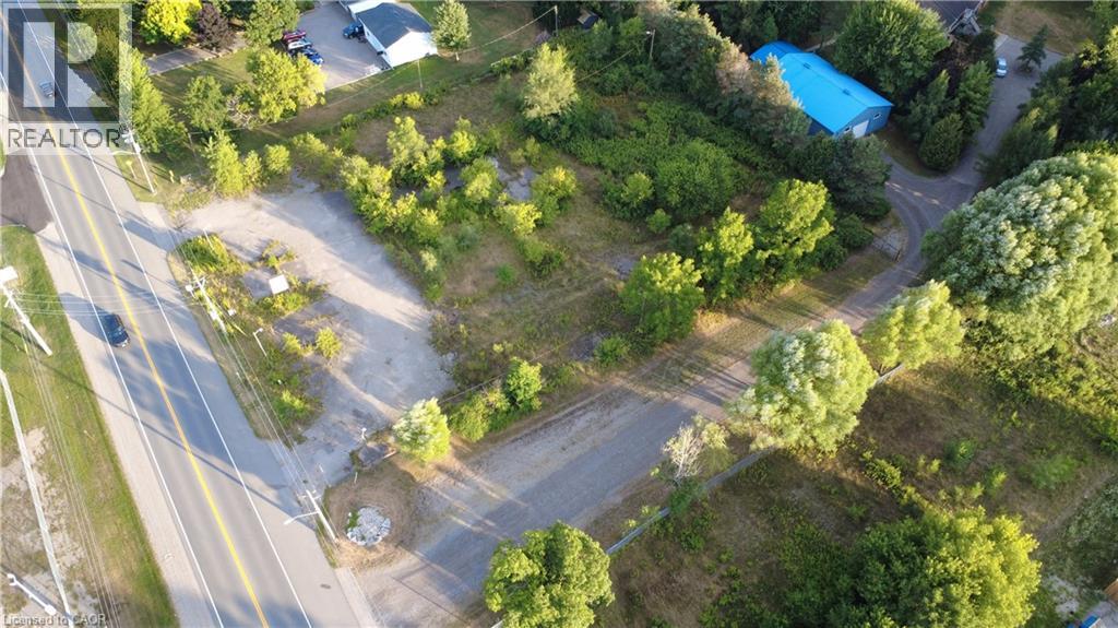 A bird's eye view of a road with a blue pool and a white building.