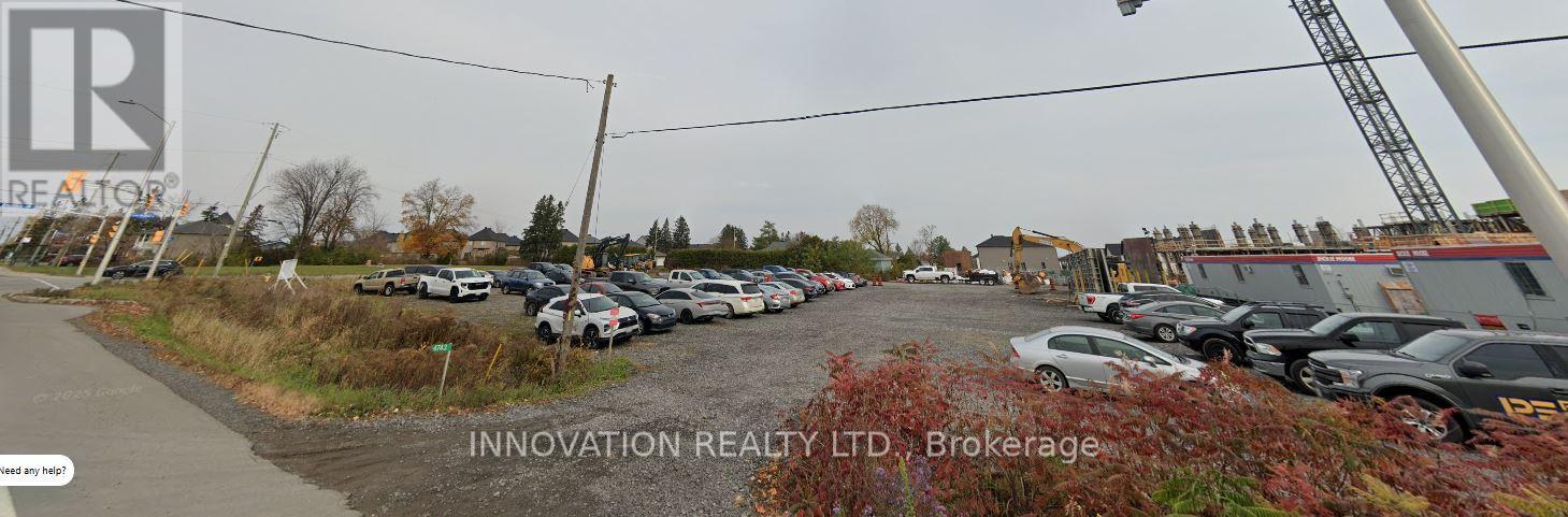 A parking lot with several cars and a sign that reads "INNOVATION REALTY LTD Brokerage".