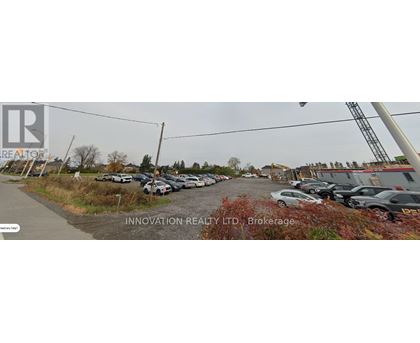 A parking lot with several cars and a sign that reads "INNOVATION REALTY LTD Brokerage".