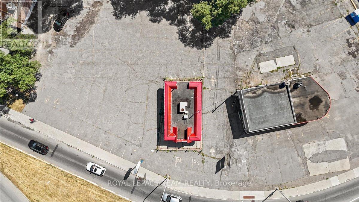 An aerial view of a parking lot with a red and black structure in the center.