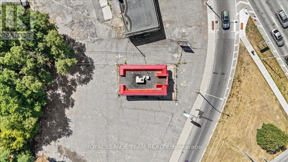 A red and white building is situated in the middle of a parking lot.