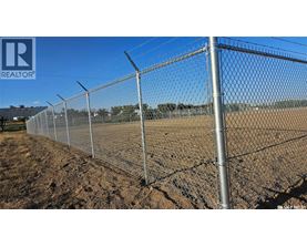 A chain link fence stretches across a field.