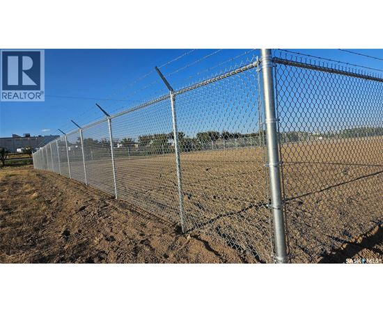 A chain link fence stretches across a field.
